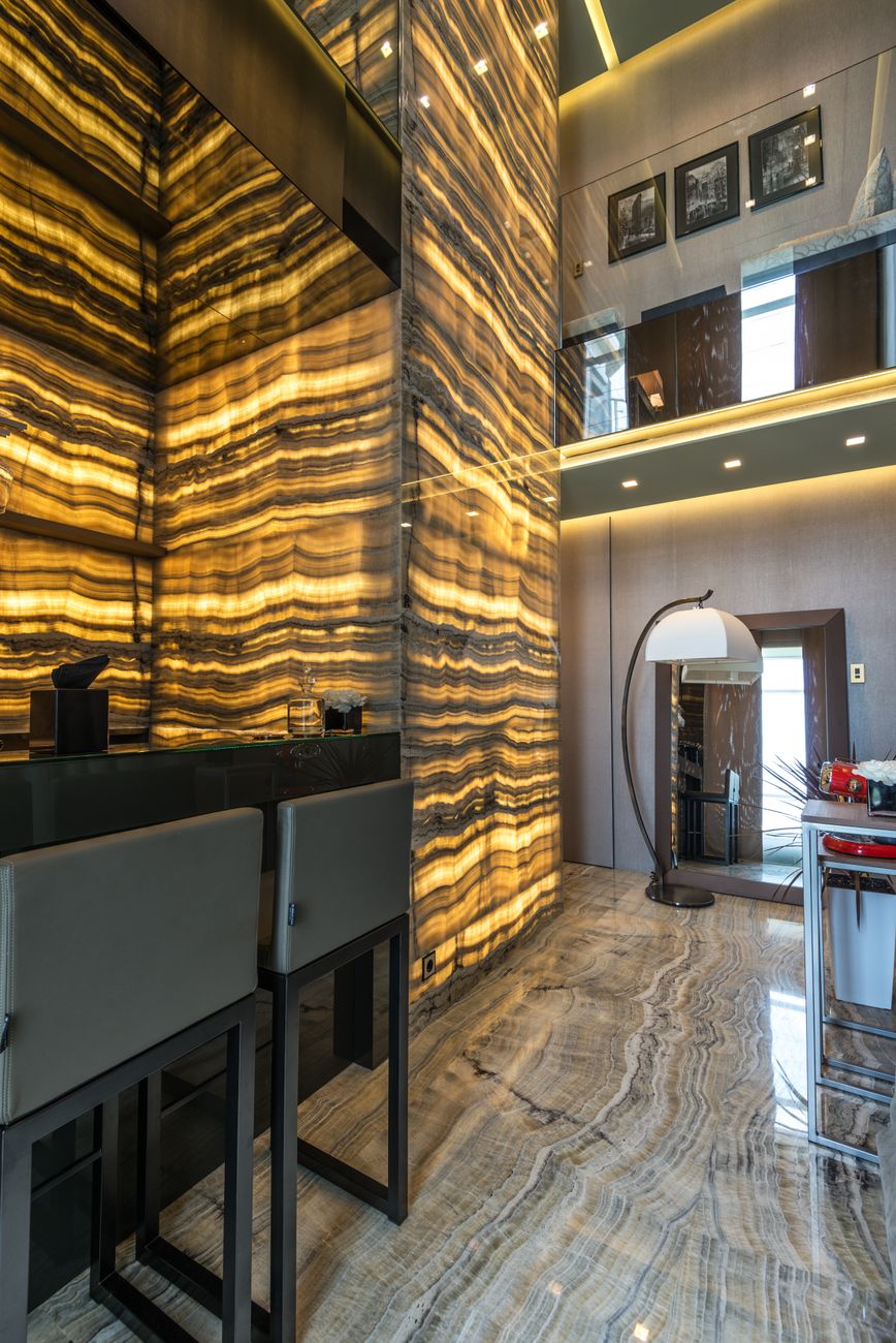 Double-height residential lobby finished in stone and brass
